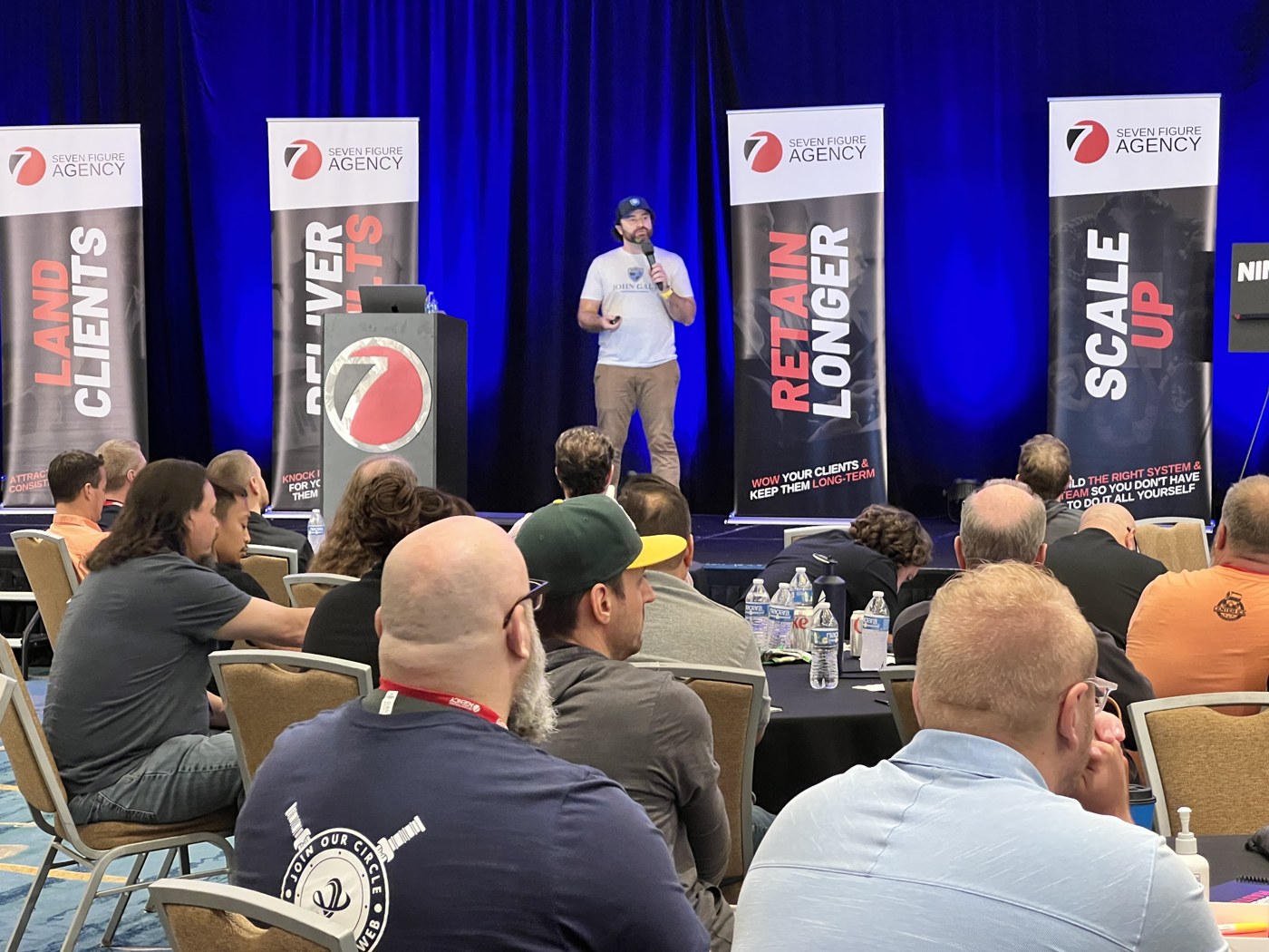 Presenting from the main stage at a Seven Figure Agency event